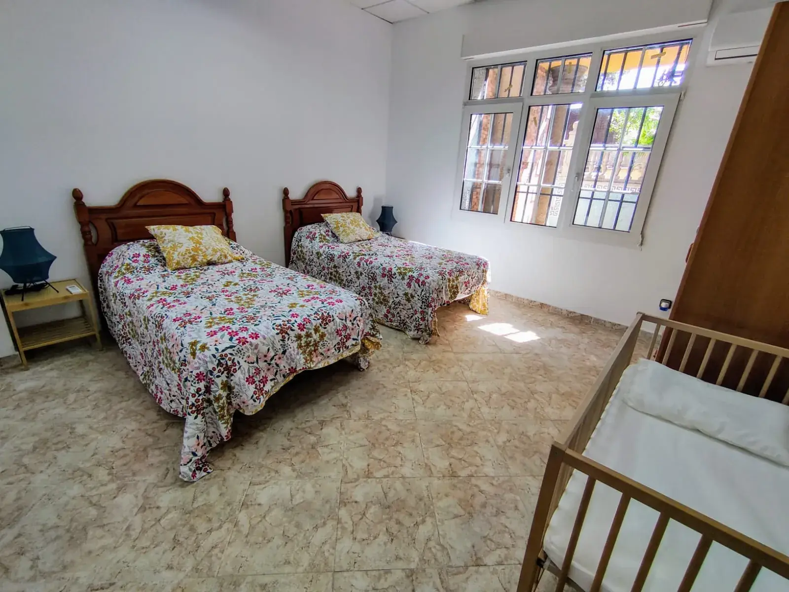 Habitación con dos camas singles, cuna y AC